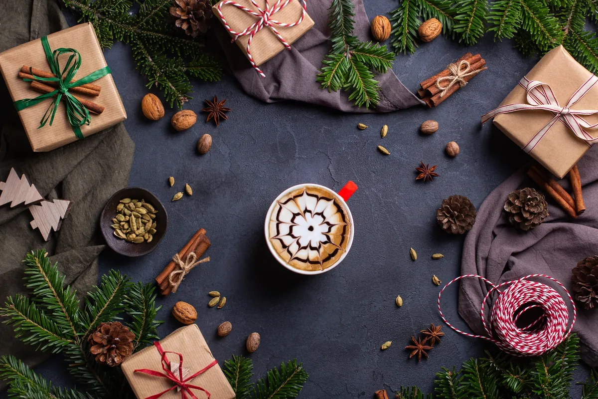Kaffee und eingepackte Weihnachtsgeschenke von oben fotografiert