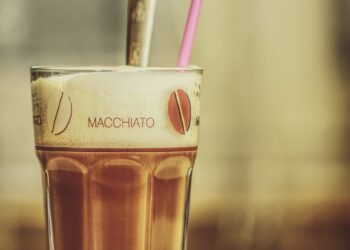 glas mit latte macchiato und pinkem Strohhalm