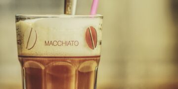 glas mit latte macchiato und pinkem Strohhalm