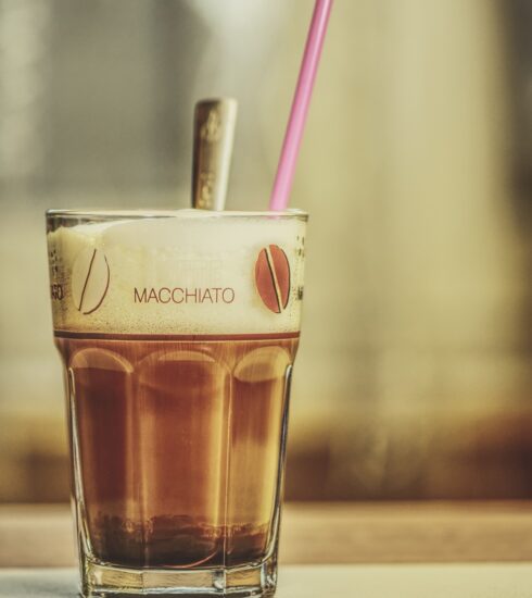 glas mit latte macchiato und pinkem Strohhalm