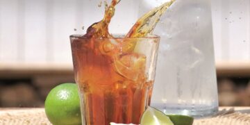 Glas mit spritzendem Cold Brew, daneben Limettenschnitze