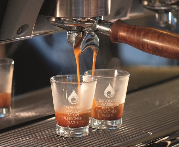 Seibtraeger mit zwei Wasserglaesern, in die Espresso reinlaeuft