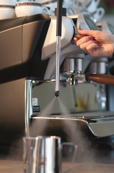 Dampflanze einer Espressomaschine stoesst Dampf aus
