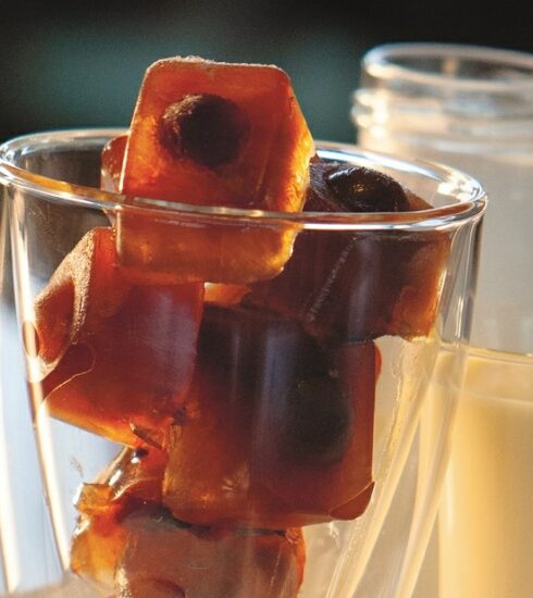 Glas mit Kaffeeeiswuerfel und Glas mit Vanillesoße und Milch daneben