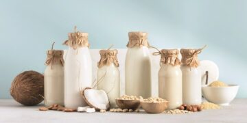 verschieden große Flaschen voll mit Milchalternativenund Nüssen