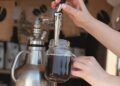 Zapfanlage, aus der in ein Glas von einer Hand Cold Brew eingelassen wird