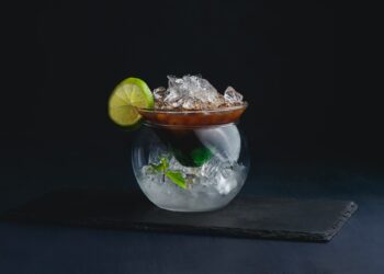 Espresso, mint and lime cocktail in a modern glass bowl. Coffee cold brew concept. Dark background
