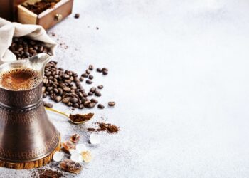 Turkish coffee brewing pot and beans on concrete with copy space