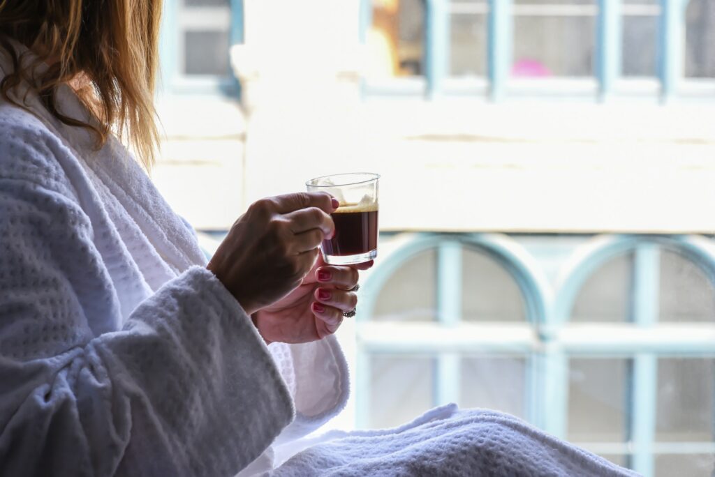 Woman sitting in window drinking espresso at luxury boutique hotel