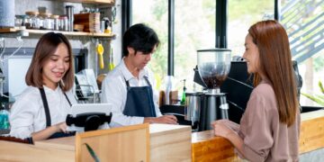 Asian barista or coffee maker receive the order from customer woman