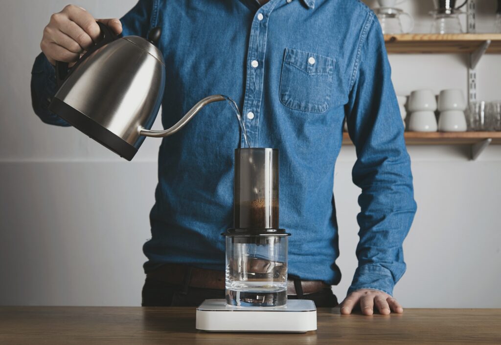 Barista pours hot water to aeropress
