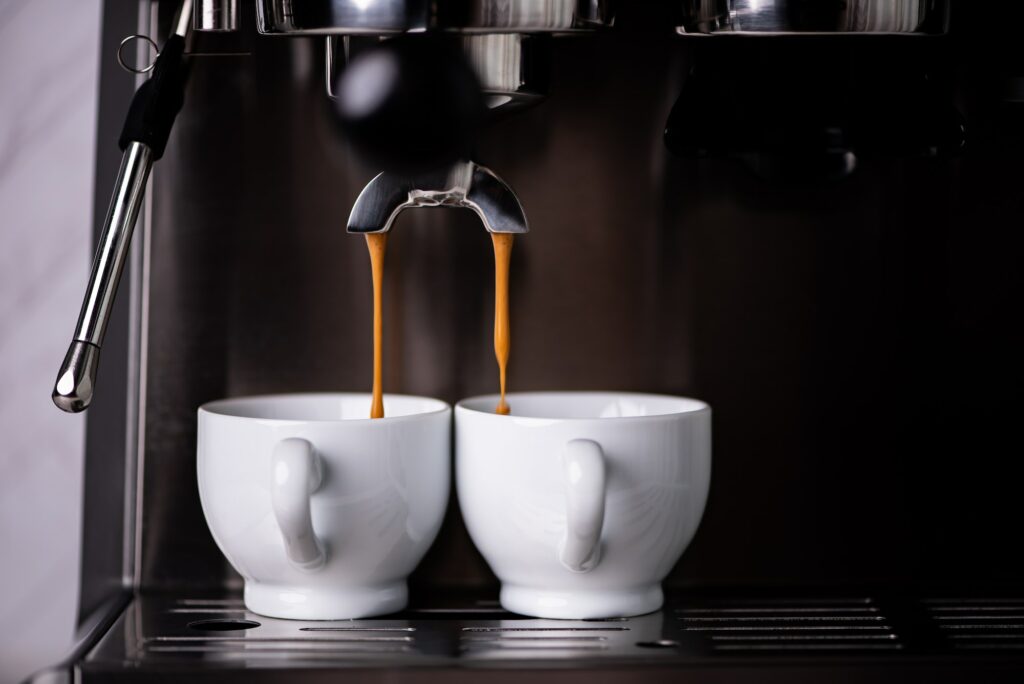 Espesso brewing into two ceramic espresso cups