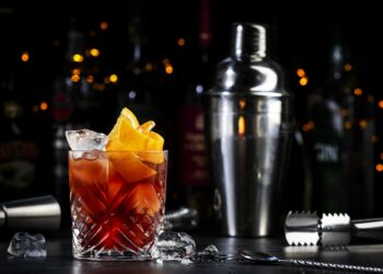 Espresso Negroni cocktail with dry gin, red vermouth and bitter, and coffee liqueur, orange and ice