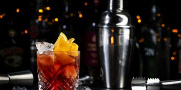 Espresso Negroni cocktail with dry gin, red vermouth and bitter, and coffee liqueur, orange and ice