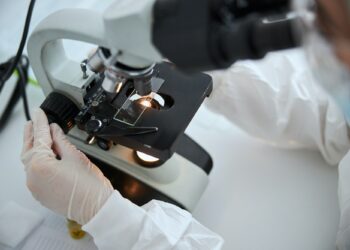 Microbiologist observing a microscopic specimen under the microscope