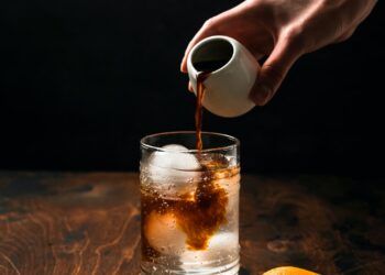 Preparing espresso tonic with orange juice