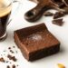 selective focus of delicious brownie piece near coffee on white background