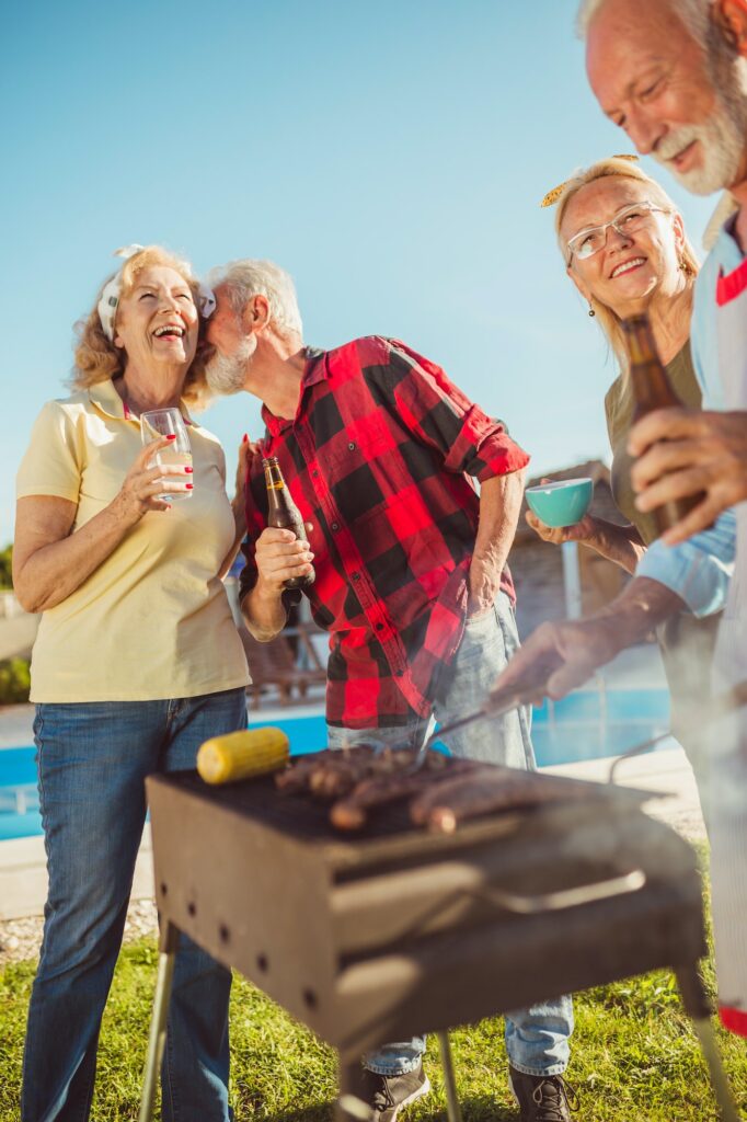 Senior people having backyard barbecue party