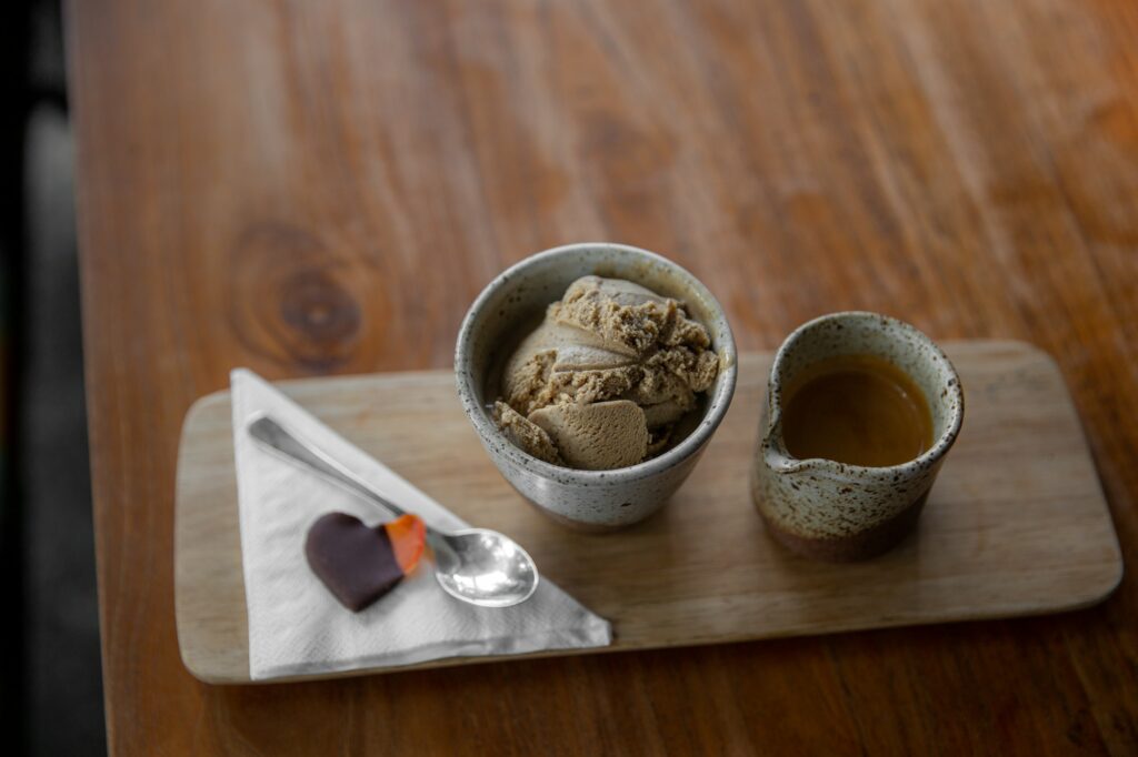 Stylish mug of espresso with chocolate ice cream on wooden table background