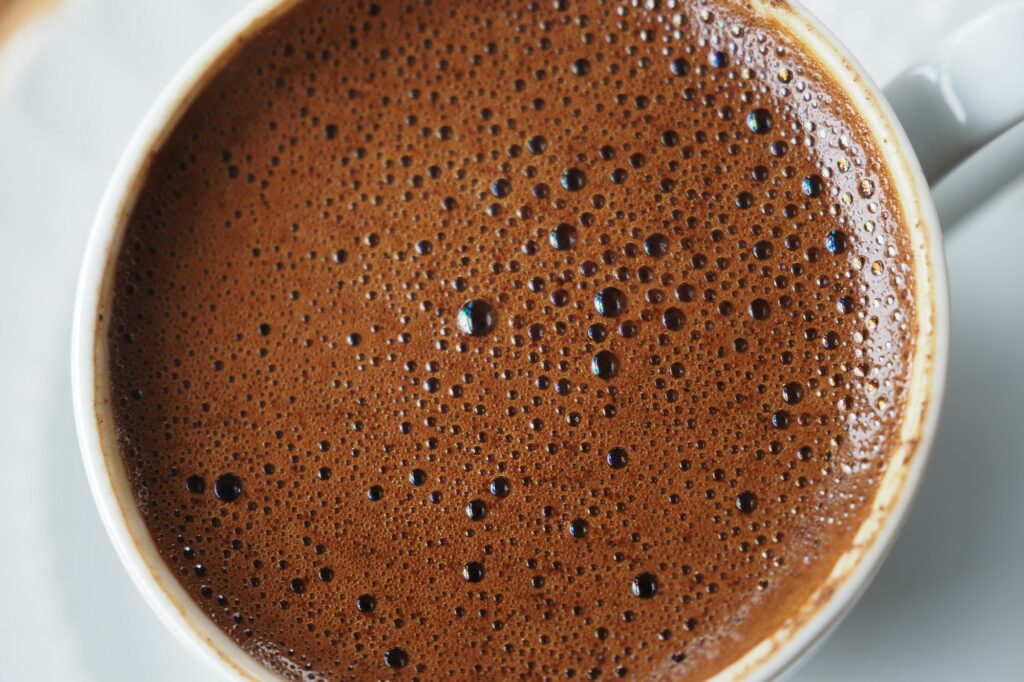 top view of hot coffee with bubble on white background