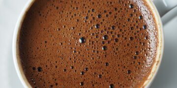 top view of hot coffee with bubble on white background