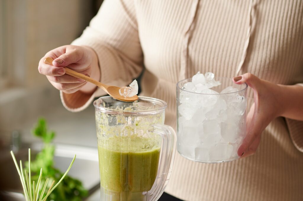 Woman Adding Ice in Smoothie