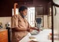 African American woman in face mask stacking coffee beans in a bowl