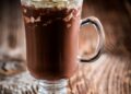 Chocolate coffee with whipped cream on wooden background