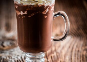 Chocolate coffee with whipped cream on wooden background