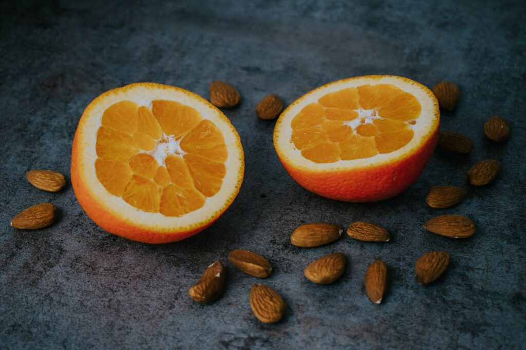 Closeup of sliced oranges and almond nuts on a gray surface