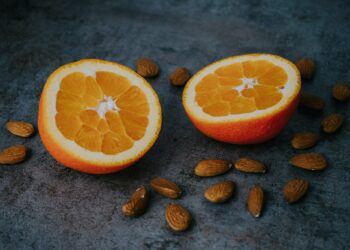 Closeup of sliced oranges and almond nuts on a gray surface