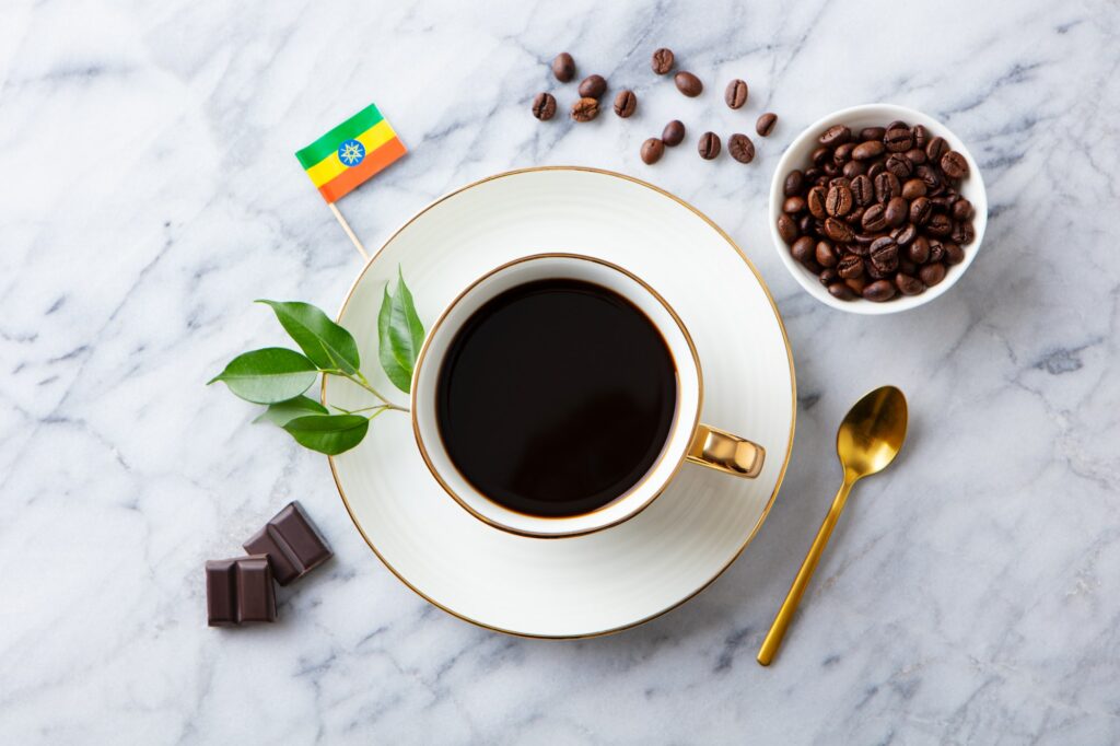 Cup of Coffee with Ethiopia flag on marble table. Top view.