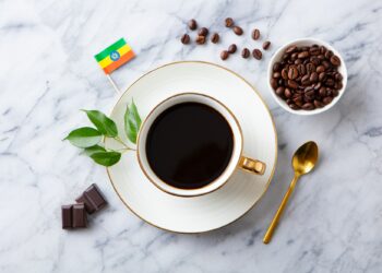 Cup of Coffee with Ethiopia flag on marble table. Top view.