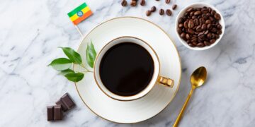 Cup of Coffee with Ethiopia flag on marble table. Top view.