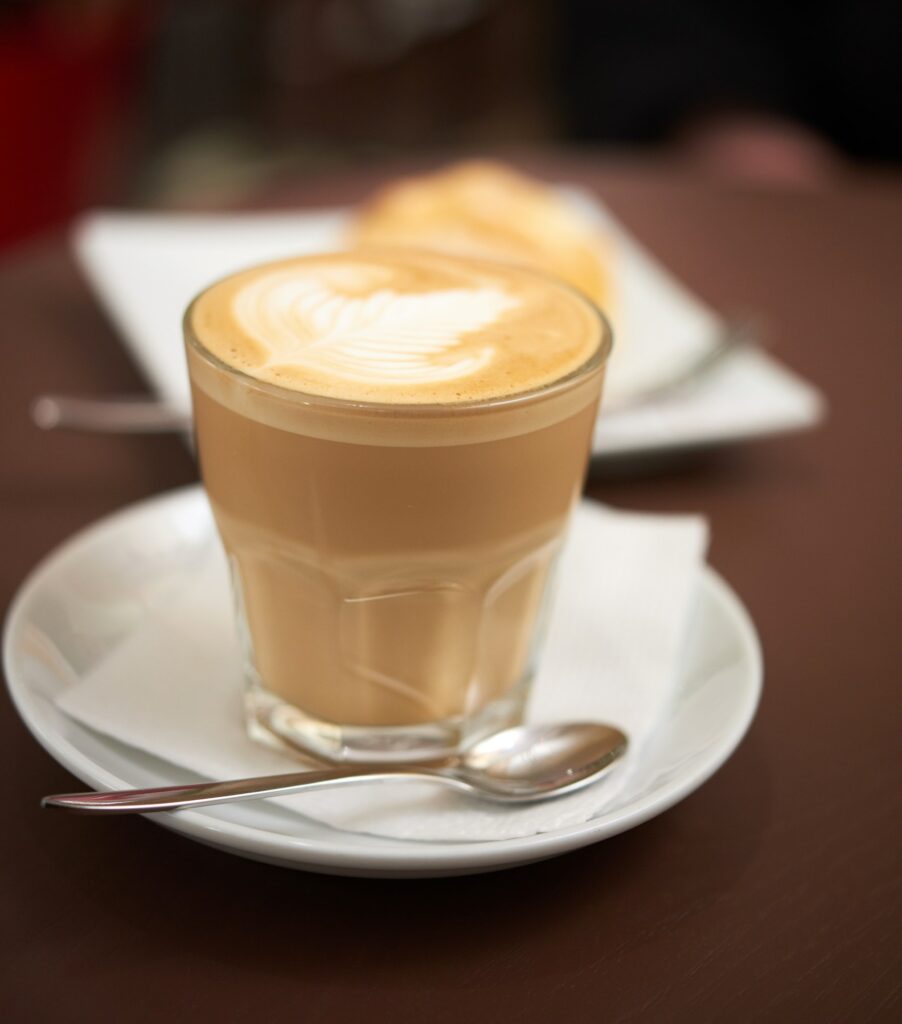 Flat white coffee in a transparent glass with white foam