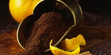 Fresh oranges and peels with cinnamon stick and freshly ground coffee in vintage scoop