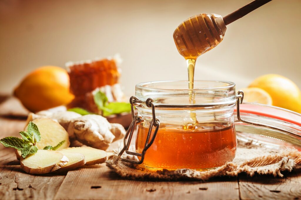 Honey in jar with ginger and lemon