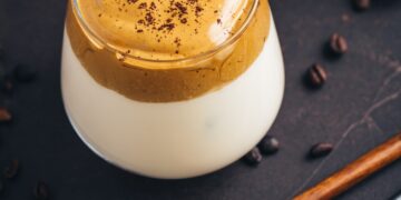 Iced fluffy creamy whipped trend drink with coffee foam and milk. Dalgona coffee.