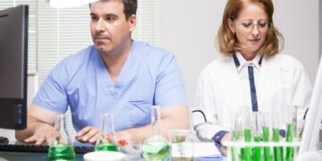 Middle age female scientist working with her assistant in a factory laborator
