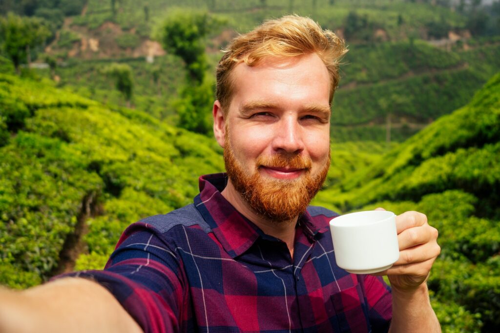 redhaired ginger male enjoying morning in India chai plantations Munnar