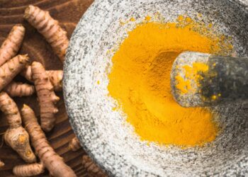 Tumeric powder superfood in granite pestle or mortar