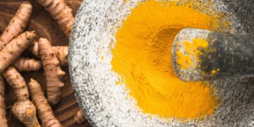 Tumeric powder superfood in granite pestle or mortar