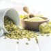 Unroasted green coffee beans on white table.