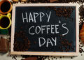 Happy coffee's day. Words on blackboard flat lay.