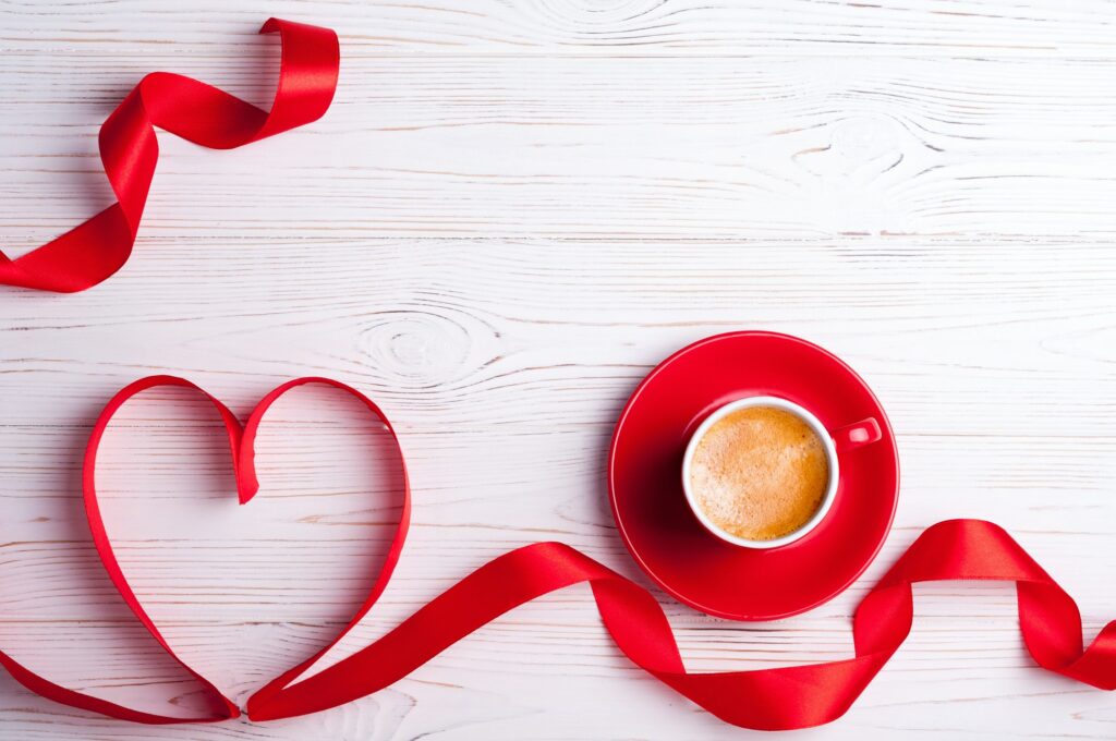 Valentines background with red heart and coffee cup. Valentines Day greeting card. Coffee break