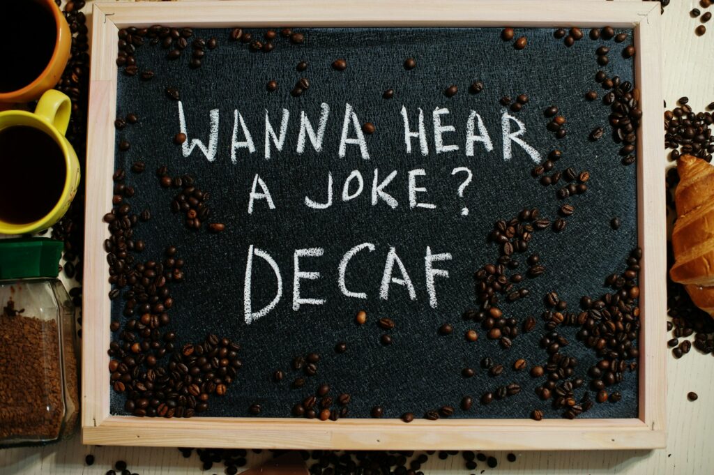 Wanna hear a joke? Decaf. Words on blackboard flat lay.