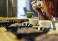 Close up woman tasting bowls of coffee at coffee shop tasting