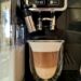 Kaffeemaschinen Fresh latte made in automatic coffee machine in glass with double heat-resistant walls.