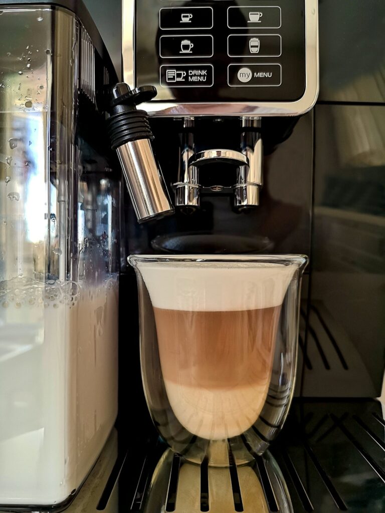 Kaffeemaschinen Fresh latte made in automatic coffee machine in glass with double heat-resistant walls.