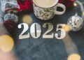 Cozy winter setup with a warm drink, festive decorations, and New Year’s numbers.